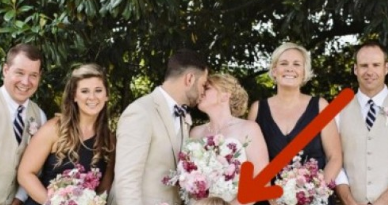 Булката и младоженеца се целуват за снимката. Но погледнете малката шаферка – тя събра погледите на всички